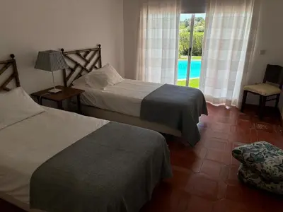 two beds in a bedroom with a view of a pool at Casa 3 in Raposeira