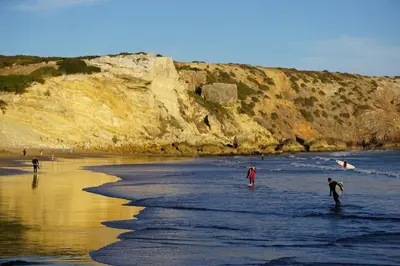 a group of people standing in the water on a beach at Casa 3 in Raposeira