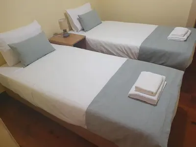 two beds in a hotel room with towels on them at Casa do Moinho - TABUA in Ribeira Brava
