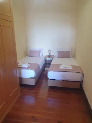 two beds in a small room with wooden floors at Casa do Moinho - TABUA in Ribeira Brava