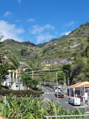 a street in a town with a mountain at Casa do Moinho - TABUA in Ribeira Brava