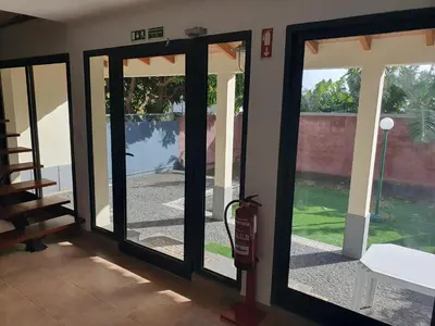 a sliding glass door with a view of a yard at Casa do Moinho - TABUA in Ribeira Brava