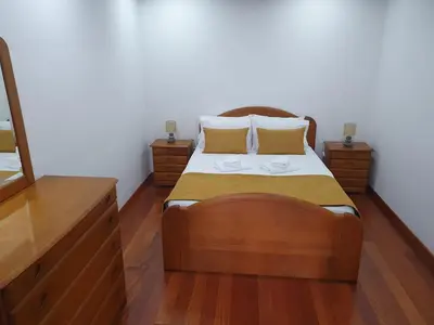 a bedroom with a wooden bed with two night stands at Casa do Moinho - TABUA in Ribeira Brava
