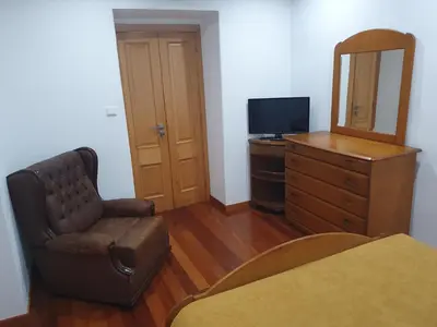 a living room with a chair and a dresser and a mirror at Casa do Moinho - TABUA in Ribeira Brava