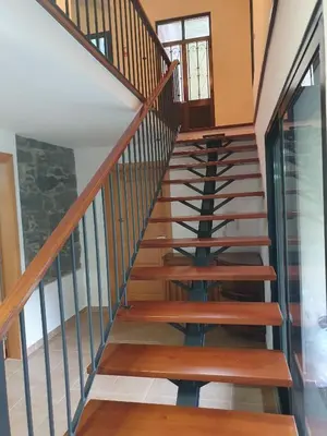 a staircase in a house with wood and metal railings at Casa do Moinho - TABUA in Ribeira Brava
