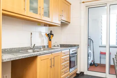 a kitchen with wooden cabinets and a sink at Caniço Lodge in Caniço