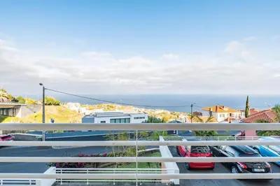 a balcony with cars parked in a parking lot at Caniço Lodge in Caniço