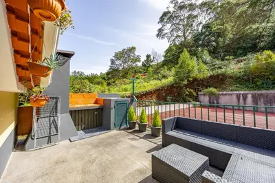 a patio with a bench and plants on a balcony at Casa da Achada by YOUR KEY in Santana