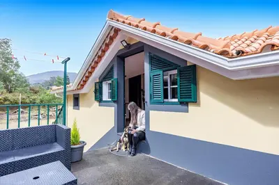 a woman sitting outside of a house at Casa da Achada by YOUR KEY in Santana
