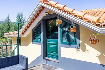 a house with a green door and windows at Casa da Achada by YOUR KEY in Santana