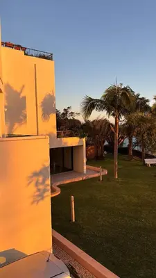 a building with palm trees in a park at Vista Praia Apartment in Funchal