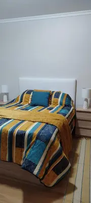 a bedroom with a bed with a comforter and pillows at Vista Praia Apartment in Funchal