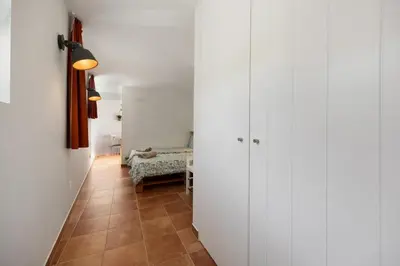 a hallway with white walls and a room with a bed at Apartment Amado - Carrapateira in Carrapateira