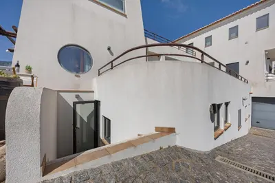 a white house with a staircase and a glass door at Apartment Amado - Carrapateira in Carrapateira