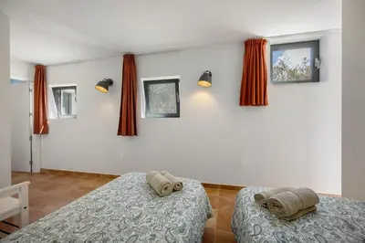 two beds in a room with red curtains at Apartment Amado - Carrapateira in Carrapateira