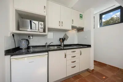 a kitchen with white cabinets and a sink at Apartment Amado - Carrapateira in Carrapateira