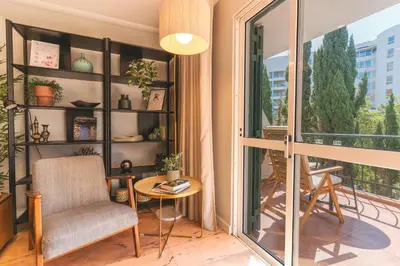 a room with a chair and a table and a balcony at Costa Azul by Atlantic Holiday in Funchal