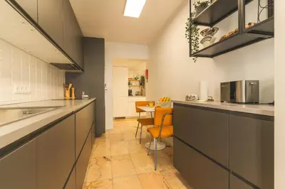 a kitchen with gray cabinets and orange chairs at Costa Azul by Atlantic Holiday in Funchal