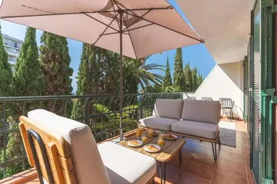 a balcony with two chairs and an umbrella at Costa Azul by Atlantic Holiday in Funchal