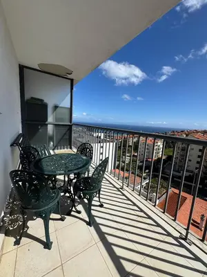 a patio with a table and chairs on a balcony at Barreiros View Vacations in Funchal