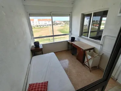 a room with a bed and a desk and two windows at Casa Francis in Aljezur