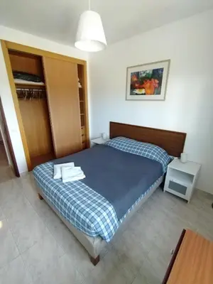 a bedroom with a bed with a blue and white blanket at Casa Francis in Aljezur