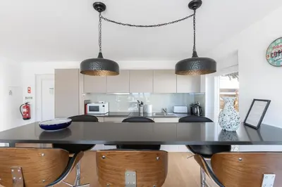 a kitchen with a large black table and chairs at Luz Home- Two Bedroom Villa in Luz
