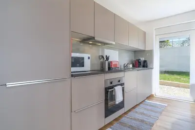 a white kitchen with a refrigerator and a microwave at Luz Home- Two Bedroom Villa in Luz