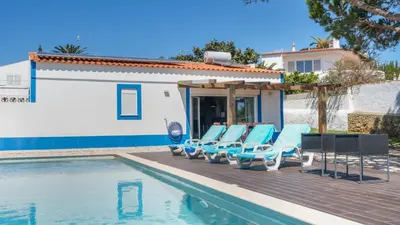 a group of lounge chairs next to a swimming pool at Luz Home- Two Bedroom Villa in Luz