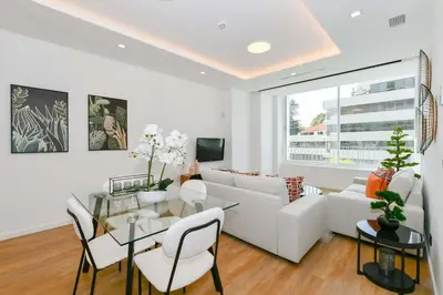 a living room with a white couch and a glass table at Cantinho do Atlântico in Funchal