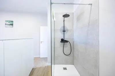 a shower with a glass door in a bathroom at Palm Breeze Loft in Estreito da Calheta