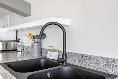 a kitchen sink with a faucet in a kitchen at Palm Breeze Loft in Estreito da Calheta