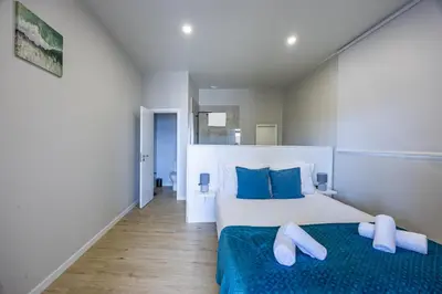 a bedroom with two beds with blue pillows at Palm Breeze Loft in Estreito da Calheta