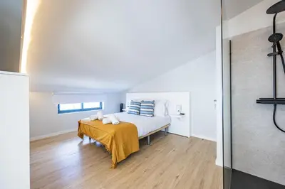 a bedroom with a bed with a yellow blanket on it at Palm Breeze Loft in Estreito da Calheta