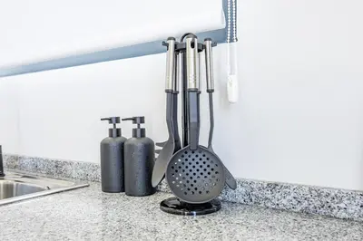 a kitchen counter with utensils on a counter top at Palm Breeze Loft in Estreito da Calheta