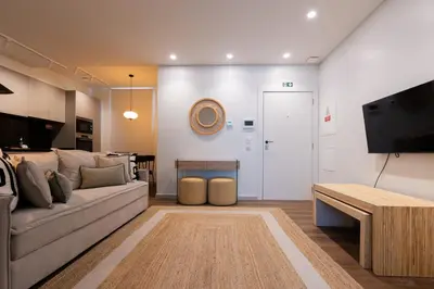 a living room with a couch and a tv at Tulip Apartments Funchal by Mercado dos Lavradores com AC in Funchal