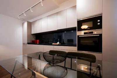 a kitchen with a glass table with two chairs at Tulip Apartments Funchal by Mercado dos Lavradores com AC in Funchal
