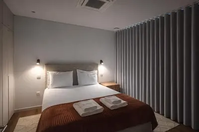 a bedroom with a bed with two towels on it at Tulip Apartments Funchal by Mercado dos Lavradores com AC in Funchal