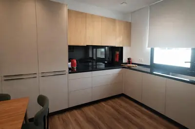 a kitchen with white cabinets and black counter tops at Tulip Apartments Funchal by Mercado dos Lavradores com AC in Funchal