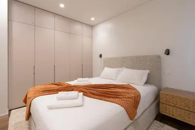 a bedroom with a large bed with two towels on it at Tulip Apartments Funchal by Mercado dos Lavradores com AC in Funchal