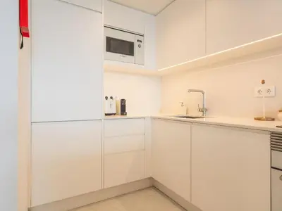 a white kitchen with white cabinets and a microwave at Glamorous Apartment by Atlantic Holiday in Funchal