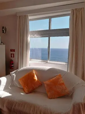 a bed with two orange pillows in front of a window at Apartamento do Mar in Funchal