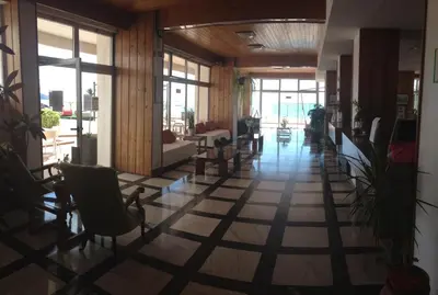 a lobby with chairs and tables and windows at Apartamento do Mar in Funchal