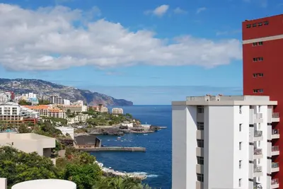 a view of the ocean and a tall building at Apartamento do Mar in Funchal