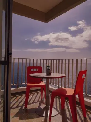 a table and chairs on a balcony with a view of the ocean at Apartamento do Mar in Funchal