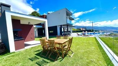 a table and chairs on the lawn of a house at Villa Nóbrega in Câmara de Lobos