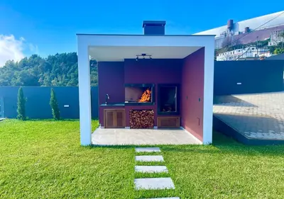 a house with a fireplace in a field of grass at Villa Nóbrega in Câmara de Lobos
