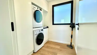 a laundry room with a washing machine and a window at Villa Nóbrega in Câmara de Lobos