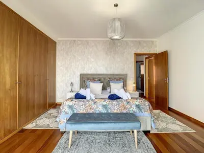 a bedroom with a large bed with a blue bench at Zen House By The Madeira Luxury Collection in Arco da Calheta