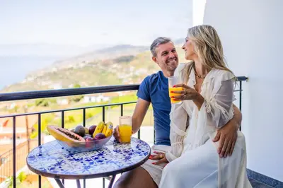 a man and a woman sitting at a table with drinks at Zen House By The Madeira Luxury Collection in Arco da Calheta